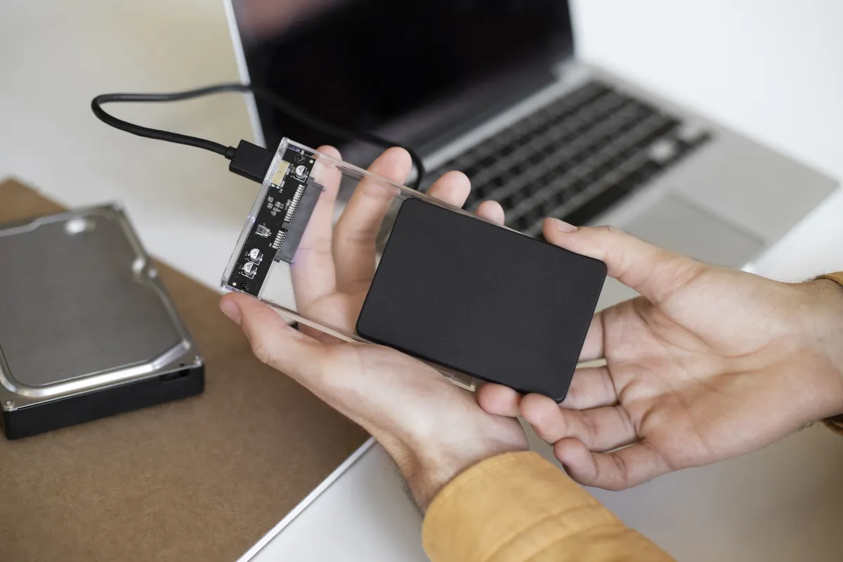 Image depicting a person holding a backup drive, symbolizing the importance of data backup and protection.